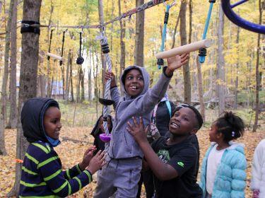  Boy reaching for rope with the support of friends